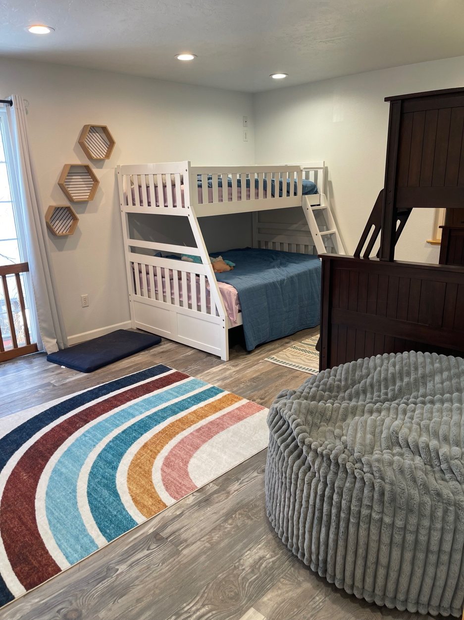 Bunk room with colorful rug and beds